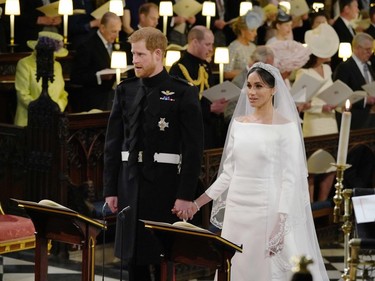 Britain's Prince Harry, Duke of Sussex (L) and US fiancee of Britain's Prince Harry Meghan Markle stand together hand in hand at the High Altar during their wedding ceremony in St George's Chapel, Windsor Castle, in Windsor, on May 19, 2018.