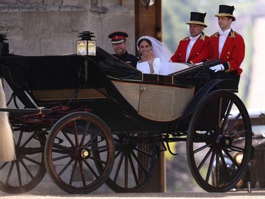 Britain's Prince Harry, Duke of Sussex (L) and his wife Meghan, Duchess of Sussex (R) arrive back at Windsor Castle in the Ascot Landau Carriage after their wedding ceremony and after their procession in Windsor, on May 19, 2018.