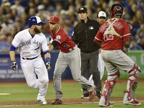 Toronto Blue Jays catcher Russell Martin (55) is tagged out by Los Angeles Angels shortstop Andrelton Simmons (2) as he is caught in a run down during fourth inning American League baseball action in Toronto on Tuesday, May 22, 2018. Toronto Blue Jays third baseman Giovanny Urshela grounded into a fielder's choice on the play.