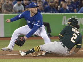 Oakland Athletics' Khris Davis slides safely into third as Toronto Blue Jays third baseman Josh Donaldson tries to make a play in the eighth inning of their American League MLB baseball game in Toronto on Saturday May 19, 2018.