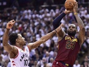 Cleveland Cavaliers forward LeBron James (23) scores over Toronto Raptors guard DeMar DeRozan (10) during second half NBA playoff basketball action in Toronto on Thursday, May 3, 2018.
