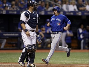 Toronto Blue Jays' Aledmys Diaz, right, scores in front of Tampa Bay Rays catcher Wilson Ramos during the eighth inning of a baseball game Saturday, May 5, 2018, in St. Petersburg, Fla.