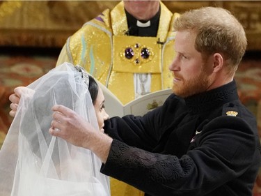 Britain's Prince Harry pulls back the veil of Meghan Markle during their wedding at St. George's Chapel in Windsor Castle in Windsor, near London, England, Saturday, May 19, 2018.