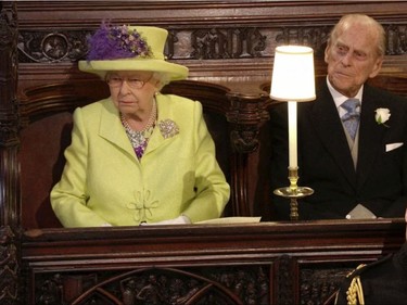 In this frame from video, Britain's Queen Elizabeth, left, Prince Philip, the Duke of Edinburgh, top right, and Britain's Prince William watch the wedding ceremony of Britain's Prince Harry and Meghan Markle at St. George's Chapel in Windsor Castle in Windsor, near London, England, Saturday, May 19, 2018.