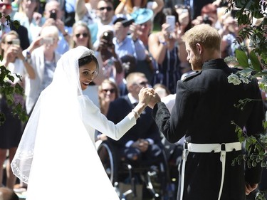 Prince Harry and Meghan Markle, left, leave St George's Chapel after the wedding ceremony in Windsor, near London, England, Saturday, May 19, 2018.