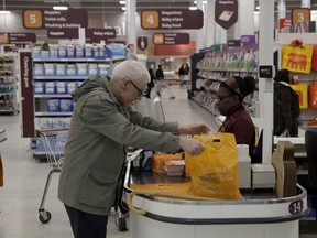 A customer buys shopping at a till in the Sainsbury's flagship store in the Nine Elms area of London, Monday, April 30, 2018.