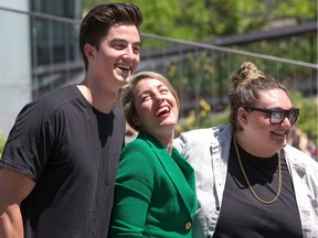 Minister Mélanie Joly has a laugh with musical performers Elijah Woods and Jamie Fine (R) after she unveiled this year's program for Canada Day celebrations in Canada's Capital Region during an announcement held on the Bank of Canada Plaza on Wednesday, May 30, 2018.