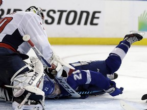 Washington Capitals goaltender Braden Holtby, left, blocks a shot as Tampa Bay Lightning center Brayden Point (21) falls forward during the second period of Game 7 of the NHL Eastern Conference finals hockey playoff series Wednesday, May 23, 2018, in Tampa, Fla.