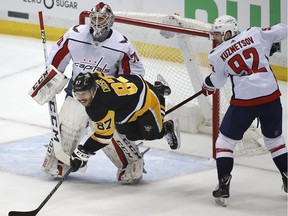 Washington Capitals' Evgeny Kuznetsov (92) defends Pittsburgh Penguins' Sidney Crosby (87) in front of goaltender Braden Holtby (70) during the first period in Game 3 of an NHL hockey second-round playoff series in Pittsburgh, Tuesday, May 1, 2018.