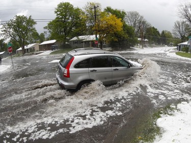 A motorist drives through a flooded intersection after a spring storm packing heavy rains and hail hit Monday, May 14, 2018, in southeast Denver. The high-powered storm swept over the area and dumped large amounts of marble-sized hail and heavy rain, snarling traffic in densely-populated parts of the metropolitan area.