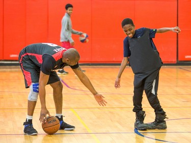 Const. Chabine Tucker (L) helps Abdoulaye on with a pair of boots and a bulletproof vest for a skills contest.