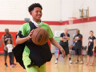 Chris is all smiles as he competes in a skills contest while wearing a bulletproof vest as Ottawa police officers volunteer their time to play basketball with teens attending the after school program run by Christie Lake Kids at the Dempsey Community Centre in Russell Heights.