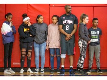 (L to R) Mirane, Aisha, Makayla, Tri-Anne, Constable Chabine Tucker, Kailea, and Amanuel. Constable Chabine Tucker waits with the kids to be sorted out on teams as Ottawa police officers volunteer their time to play basketball with teens attending the after school program run by Christie Lake Kids at the Dempsey Community Centre in Russell Heights.  Photo by Wayne Cuddington/ Postmedia