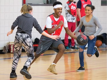 Ibrahim (c) dribbles through the defence of Kailea (L) and Tri-Anne (R).