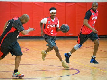 Ibrahim (C) dribbles away from police officers Chabine Tucker, (R), and Kevin Williams (L).
