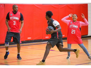 Muhamed (C) tries to dribble past Const. Chabine Tucker (L) and Makayla (R).