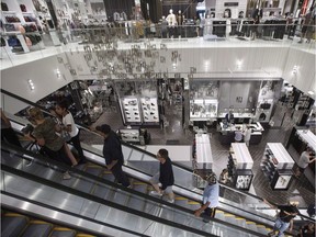 Shoppers ride an escalator.
