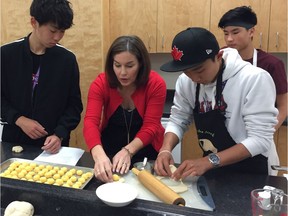 Earl of March food and culture teacher Nancy Watzenboeck makes perogies with Hiroto Tanaka, left, Ryohei Okuma, right, and Owen Marriner, rear.