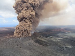 File - In this Friday, May 4, 2018, file image released by the U.S. Geological Survey, at 12:46 p.m. HST, a column of robust, reddish-brown ash plume rises after an earthquake shook the Big Island of Hawaii, Hawaii. The lava hisses, crackles and pops. It roars like an engine as it sloshes and bubbles. It shoots into the sky, bright orange and full of danger, or oozes along the pavement, a giant bubbling blob of black marshmallow-like fluff, crushing homes and making roads impassable. (U.S. Geological Survey via AP, File)