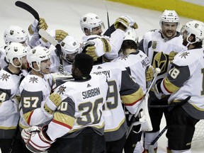 Vegas Golden Knights players hug after a 3-0 win over the San Jose Sharks during Game 6 of an NHL hockey second-round playoff series, Sunday, May 6, 2018, in San Jose, Calif.