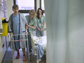 Physiotherapist Ellen Newbold (centre) helps Tim Heenan walk as he prepares for his release following day surgery for a hip replacement that morning