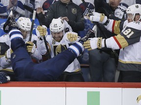 Winnipeg Jets' Blake Wheeler (26) gets dumped over the Vegas boards by Vegas Golden Knights' Ryan Reaves (75) in front of Cody Eakin (21), Oscar Lindberg (24) and Jonathan Marchessault (81) during first period of game one action in the NHL Western Conference Final in Winnipeg on Saturday, May 12, 2018.