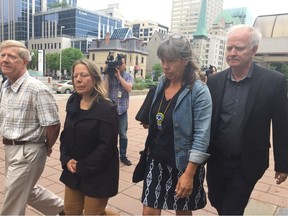 Elisabeth Salm's husband Lyle Young, sister Luc-Anne Salm, sister-in-law Vicky Boldo and Lyle's brother Lauren Young leave the Ottawa courthouse Monday after accused killer Tyler Hikoalok appeared by video.