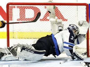 Winnipeg Jets goalie Connor Hellebuyck dives as he deflects a shot by the Nashville Predators during the third period in Game 5 Saturday.