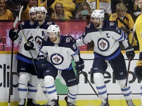 Winnipeg Jets left wing Kyle Connor (81) celebrates with Josh Morrissey, Mark Scheifele and Blake Wheeler, from left, after Connor scored a goal against the Nashville Predators during the second period in Game 5 of an NHL hockey second-round playoff series Saturday, May 5, 2018, in Nashville, Tenn. (AP Photo/Mark Humphrey) ORG XMIT: TNMH109