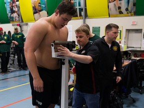 Alberta Golden Bears offensive lineman Mark Korte is weighed by Washington Redskins scout Darryl Franklin during a pro day in Edmonton on March 27, 2018