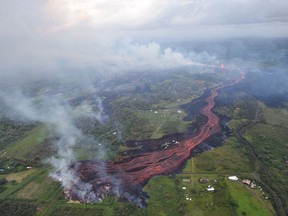 In this Saturday, May 19, 2018, released by the U.S. Geological Survey, lava emerges from fissures near Pahoa, Hawaii. Kilauea volcano began erupting more than two weeks ago and has burned dozens of homes, forced people to flee and shot up plumes of steam from its summit that led officials to distribute face masks to protect against ash particles. (U.S. Geological Survey via AP)