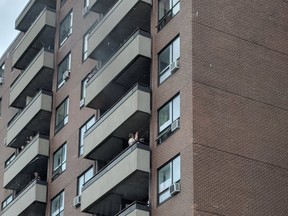 Residents watch from balconies at a fire at a medium-rise apartment building in the Vanier district Saturday.
