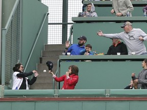 A three-run home run by Boston Red Sox's Andrew Benintendi drops between two fans in the Green Monster seats at Fenway Park in the fourth inning of a baseball game against the Toronto Blue Jays, Monday, May 28, 2018, in Boston.