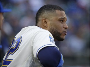 In this Sept. 24, 2017, file photo, Seattle Mariners' Robinson Cano watches from the dugout during a baseball game against the Cleveland Indians in Seattle. Cano has been suspended 80 games for violating baseball's joint drug agreement, the league announced Tuesday, May 15, 2018.