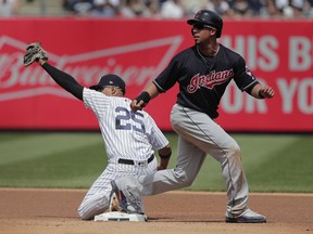 New York Yankees second baseman Gleyber Torres (25) holds up the ball as Cleveland Indians' Michael Brantley looks for the call on a force out at second base during the fourth inning of a baseball game, Saturday, May 5, 2018, in New York. Brantley was out at second.
