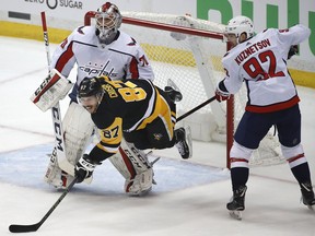 Washington Capitals' Evgeny Kuznetsov (92) defends Pittsburgh Penguins' Sidney Crosby (87) in front of goaltender Braden Holtby (70) during the first period in Game 3 of an NHL hockey second-round playoff series in Pittsburgh, Tuesday, May 1, 2018.