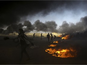 Palestinian protesters burn tires during a protest at the Gaza Strip's border with Israel, east of Khan Younis, Tuesday, May 15, 2018. Israel faced a growing backlash Tuesday and new charges of using excessive force, a day after Israeli troops firing from across a border fence killed dozens of Palestinians and wounded more than 2,700 at a mass protest in Gaza.