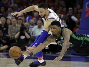 Boston Celtics' Marcus Smart, right, and Philadelphia 76ers' Ben Simmons chase after a loose ball during the first half of Game 3 of an NBA basketball second-round playoff series, Monday, May 7, 2018, in Philadelphia.