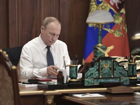 Vladimir Putin sits in his Kremlin cabinet prior his inauguration ceremony as new Russia's president in Moscow, Russia, Monday, May 7, 2018. Putin won the six-year term in March elections where he tallied 77 percent of the vote.