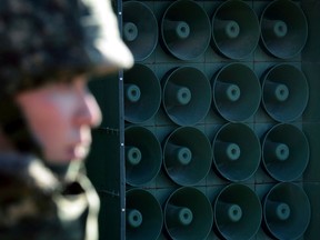 FILE - In this Friday, Jan. 8, 2016 file photo, a South Korean army soldier stands near the loudspeakers near the border area between South Korea and North Korea in Yeoncheon, South Korea. South Korea on Monday, April 30, 2018, said it will remove propaganda-broadcasting loudspeakers from the tense border with North Korea. The announcement came three days after the leaders of the two Koreas agreed to work together to achieve a nuclear-free Korean Peninsula and end hostile acts against each other along their border during their rare summit talks.