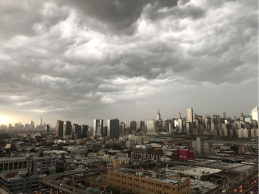 In this Tuesday, May 15, 2018 photo, storm clouds gather over New York City. A line of strong storms pushed across New York City and badly disrupted the evening commute, stranding thousands of train riders. (Garrett Amini via AP) ORG XMIT: NY201