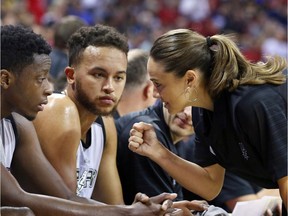 Becky Hammon talks with San Antonio Spurs' Kyle Anderson and Cady Lalanne during an NBA summer league basketball game.