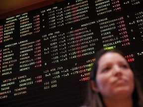 A board behind Aracely Geraci displays game odds at the South Point hotel-casino in Las Vegas on Monday, May 14, 2018. Nevada currently has a monopoly on legal sports betting in the U.S.