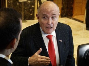 FILE - In this Jan. 12, 2017, file photo, former New York City Mayor Rudy Giuliani talks with reporters in the lobby of Trump Tower in New York. Giuliani's revelation that U.S. President Donald Trump reimbursed his personal attorney for a $130,000 payment to a porn star to keep her quiet about an alleged affair is raising new legal questions, including whether the president and his campaign violated campaign finance laws. Giuliani insisted on Fox News Channel Wednesday night, May 2, 2018, that the payment to adult film actress Stormy Daniels was "going to turn out to be perfectly legal."