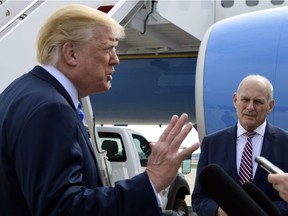 White House chief of staff John Kelly, right, listens as President Donald Trump speaks to reporters before boarding Air Force One at Andrews Air Force Base in Md., Friday, May 4, 2018. Trump is traveling to Dallas where he will address the NRA convention.