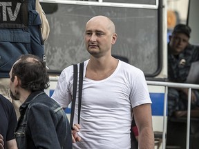 In this photo taken on Friday, May 31, 2013, Arkady Babchenko, 41, who had been scathingly critical of the Kremlin in recent years, stands at a police bus during an opposition rally in Moscow, Russia.