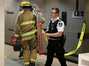 Firefighters enter a women's washroom in the CORE shopping centre food court, where a body was discovered inside a wall on April 30.