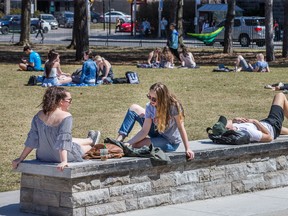 Students spread out on the lawn in front of Tabaret Hall at the University of Ottawa to study as temperatures in the region started to feel more like spring.  Photo by Wayne Cuddington/ Postmedia
