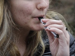 An unidentified 15-year-old high school student uses a vaping device.