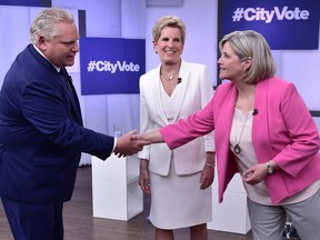 Liberal Premier Kathleen Wynne, centre, looks as Progressive Conservative Leader Doug Ford, left, and NDP Leader Andrea Horwath shake hands at the Ontario Leaders debate in Toronto on Monday, May 7, 2018.